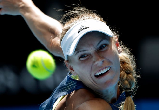 FILE - In this Jan. 25, 2018, file photo, Denmark's Caroline Wozniacki eyes the ball to make a return to Belgium's Elise Mertens during their semifinal at the Australian Open tennis championships in Melbourne, Australia. Wozniacki is expected to compete in the Wimbledon tennis tournament that begins Monday, July 2, 2018. (AP Photo/Vincent Thian, File)