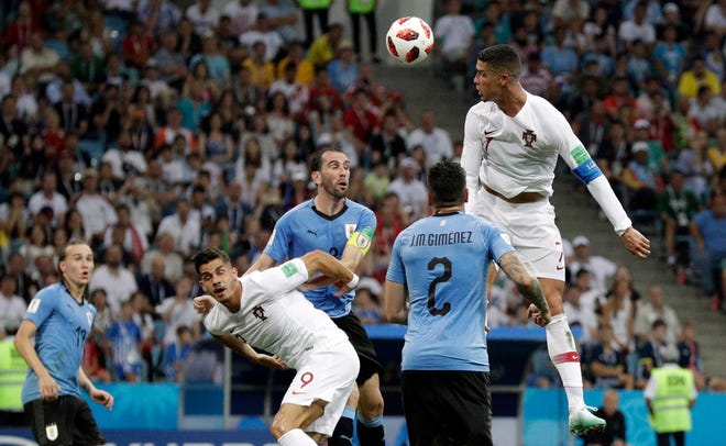 Portugal's Cristiano Ronaldo, right, heads the ball during the round of 16 match between Uruguay and Portugal at the 2018 soccer World Cup at the Fisht Stadium in Sochi, Russia, Saturday, June 30, 2018. (AP Photo/Andrew Medichini)
