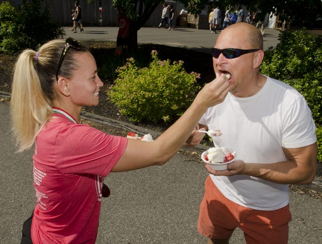 Trina Henderson has Todd Upton sample her strawberry cheesecake at the 43rd annual South Berwick Strawberry Festival on the grounds of the Central School on Saturday. [Daryl Carlson/Fosters.com]