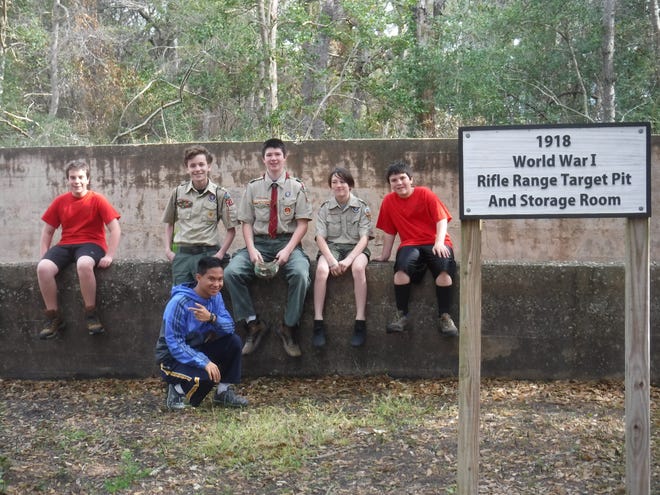 Eagle Scout candidate Ethan Pannkuk (center, wearing tie) sits with fellow members of Carolina Beach's Troop 210 at the 1918 Fort Caswell Rifle Range in Caswell Beach, where they removed tree roots and relieved pressure on a wall of the World War I range. [CONTRIBUTED PHOTO]