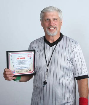 Jon Jamison poses with his award in recognition of 25 years as a wrestling official. PHOTO BY LIBBIE RANDALL/THE PERRY CHIEF