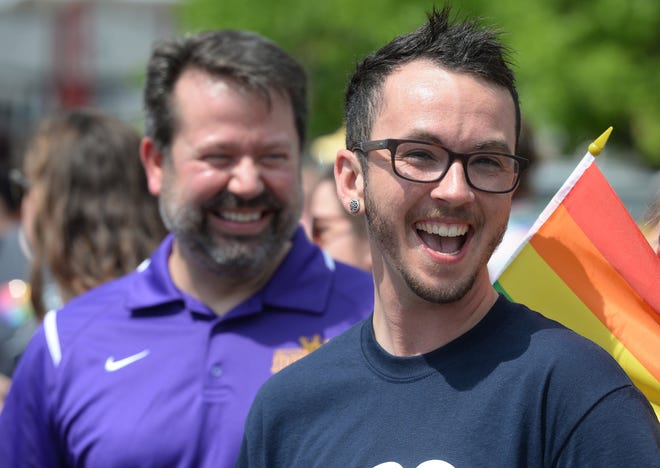 Erie School District Superintendent Brian Polito, left, and Erie School Board member Tyler Titus, right, march in the Erie Pride parade on Saturday. [JACK HANRAHAN/ERIE TIMES-NEWS]