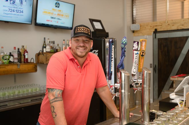 Sam Burns stands in his new bar, The Reserve, which opened in June at 115 N. Main St. [Ben Coley/The Dispatch]