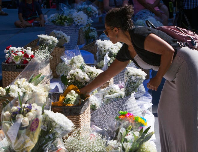 Marisol Avelar of Boise adds a bouquet of white flowers to a growing pile during a vigil at City Hall in Boise, Idaho, Monday, July 2, 2018. A 3-year-old Idaho girl who was stabbed at her birthday party died Monday, two days after a man invaded the celebration and attacked nine people with a knife, authorities said. (Darin Oswald/Idaho Statesman via AP)