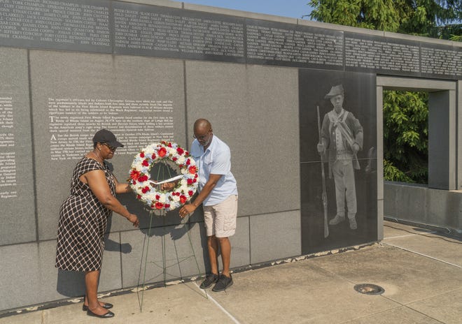 Josephine Brown and Dereke Mays lay a wreath at the Black Regiment Monument during an Independence Day ceremony Wednesday at Patriots Park in Portsmouth. [DAVE HANSEN/STAFF PHOTOGRAPHER]