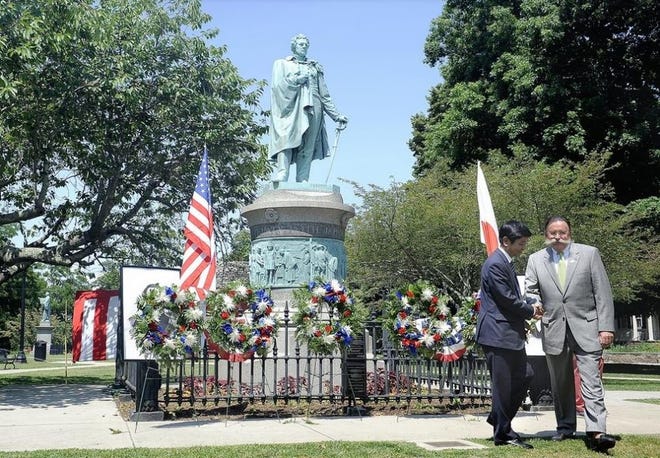 Newport Mayor Harry Winthrop shakes hands with Shimoda City Assembly Chairman Shinoba Tsuchiya after presenting a wreath in front of the statue of Commodore Mathew Perry durin the opening ceremonies for the Newport Black Ships Festival in 2014. [DAILY NEWS FILE PHOTO]
