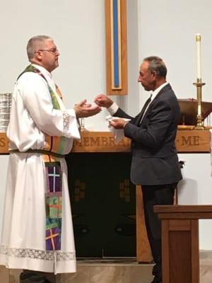Vince Locona, pastor of St. Mark by the Sea, and Viktor Ostapenko, pastor of Emanuel Slavic Church, share communion at a Unity Service July 1. [Contributed]