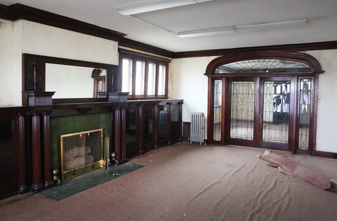 A set of double doors encased in an archway of leaded, jeweled glass separates two rooms inside the Crosby Mansion. Built-in mahogany bookshelves surround the fireplace, which has a hand-carved mantel. [Thad Allton/The Capital-Journal]