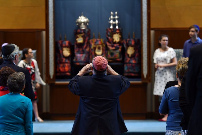 A congregant photographs the Torah in the renovated synagogue. [T&G Staff/Christine Peterson]
