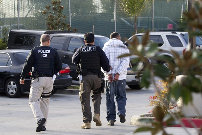 Immigration and Customs Enforcement agents take a suspect into custody. [AP Photo/Gregory Bull/File]