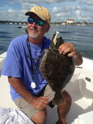 Mike Hayes shows a chunky flounder caught in St. Augustine, on an otherwise tough day of fishing with a cool flood tide. [Bob McNally/For the Times-Union]