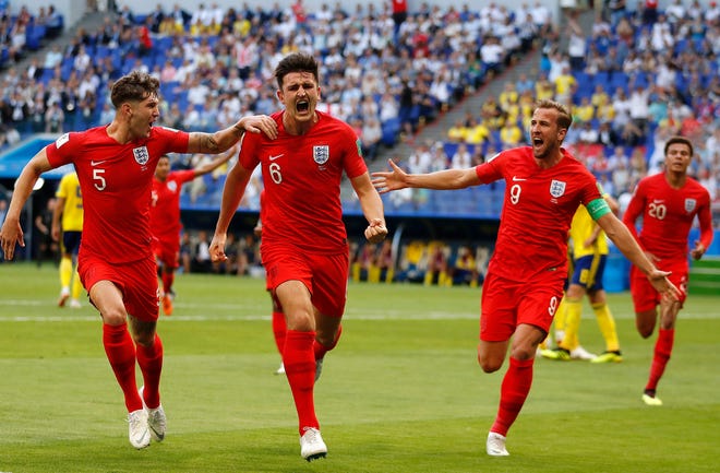 England's Harry Maguire (center) celebrates with his teammates after scoring the game's opening goal in Saturday's 2-0 quarterfinal win over Sweden in Samara, Russia. [AP Photo/Francisco Seco]