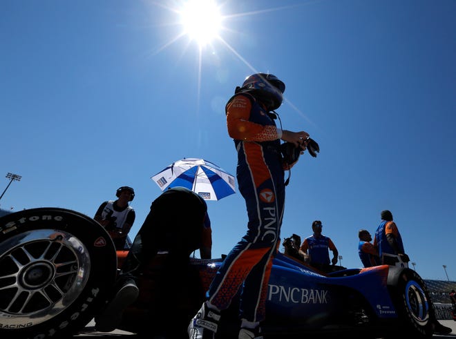 Scott Dixon stands next to his car during Saturday's qualifying for Sunday's IndyCar Series Iowa Corn Indy 300 at Iowa Speedway in Newton. [Charlie Neibergall/The Associated Press]