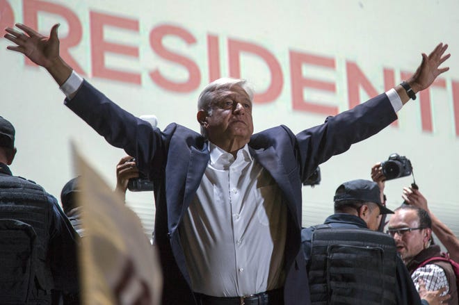 Presidential candidate Andres Manuel Lopez Obrador acknowledges his supporters as he arrives to Mexico City's main square, the Zocalo, Sunday, July 1, 2018. Lopez Obrador has claimed victory in Mexico's presidential election, calling for reconciliation. [AP Photo/Anthony Vazquez]