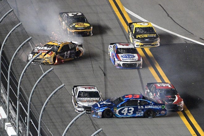 Clint Bowyer (14) and Darrell Wallace Jr (43) spin on the front stretch, starting a multi-car accident Saturday night in the Coke Zero Sugar 400 at Daytona International Speedway. [Phelan M. Ebenhack/The Associated Press]
