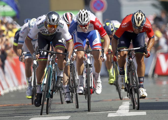 Slovakia's Peter Sagan, left, Italy's Sonny Colbrelli, right, and France's Arnaud Demare sprint to the finish line during the second stage of the Tour de France in La Roche Sur-Yon, France, Sunday. Sagan won the stage. [The Associated Press / Christophe Ena]