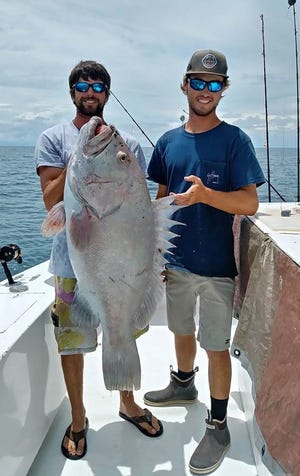 Backdown 2 first mate AJ Niemiec, left, and second mate Chase show off the white Warsaw grouper right after they got it aboard the Backdown 2. [CONTRIBUTED PHOTO]