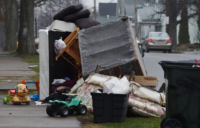 Furniture and garbage is piled up in front of homes in the 600 block of East Eighth Street in Erie on April 3. The city's large item trash pickup is underway. During the cleanup, city residents are able to get rid of one unwanted large item each week along with their regular household trash. [JACK HANRAHAN/ERIE TIMES-NEWS]