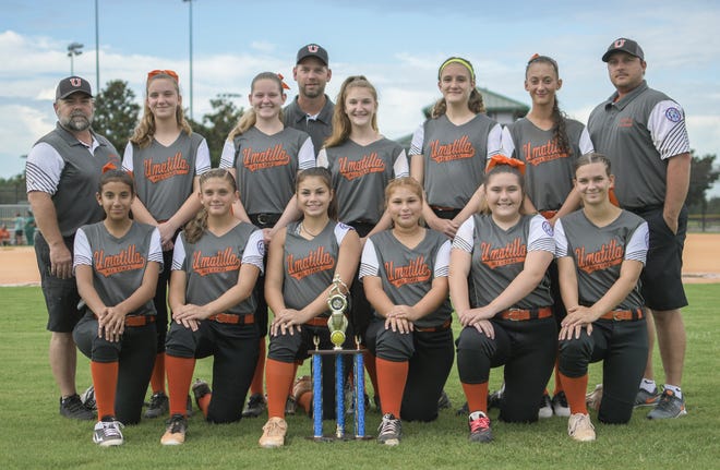 The Umatilla Babe Ruth 14U softball team poses with the state championship trophy at a practice session at North Lake Community Park in Umatilla recently. [PAUL RYAN / CORRESPONDENT]