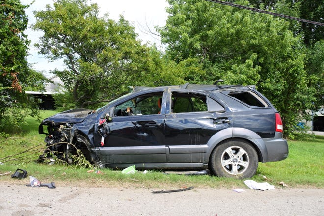 A vehicle lies damaged on the side of the road after striking two utility poles and a gas meter Monday, July 9, 2018. [THOMAS SACCENTE/TIMES RECORD]