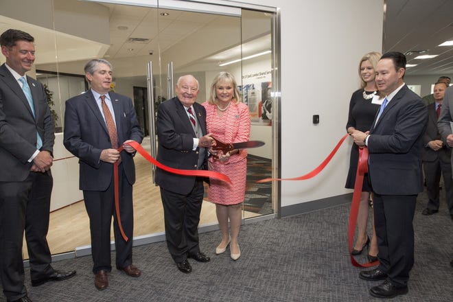 Oklahoma City Mayor David Holt, from left, joins CACI Chief Operating Officer John Mengucci, Executive and Board Chairman J.P. (Jack) London, Gov. Mary Fallin, CACI Vice President Jackie Hughes and CACI Executive Vice President and Shared Services Officer Tom Nesteruk in cutting a ribbon at the firm's new shared services center in Oklahoma City on Tuesday. [Photo provided by Simon Hurst]