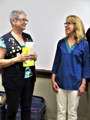 Judy Decker, a board member with the St. Augustine Lions Club, presents a donation to Hands for Hope president Susan Herrera. [Contributed]