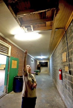Debbie Hoyle shows wood damage inside the gym at the Belwood Community Center. [Brittany Randolph/The Star]