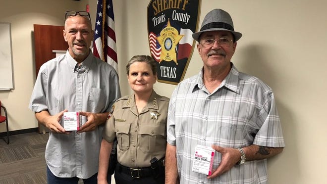 Texas Overdose Naloxone Initiative co-founders Mark Kinzly, left, and Charles Thibodeaux, right, gave the Travis County sheriff’s office this week doses of the drug naloxone, which reverses the effects of an opioid overdose. Travis County Sheriff Sally Hernandez, center, thanked them in a post online. CONTRIBUTED PHOTO