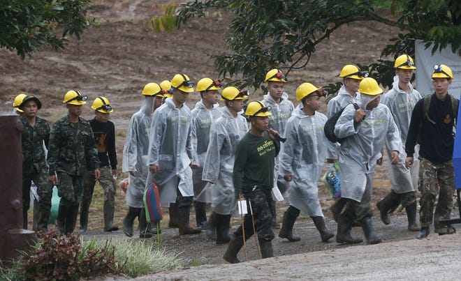 Rescuers walk toward the entrance to a cave complex where five were still trapped, in Mae Sai, Chiang Rai province, northern Thailand Tuesday, July 10, 2018. The eight boys were rescued from the flooded cave. (AP Photo/Sakchai Lalit)