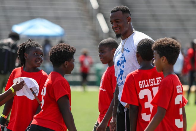 Mike Gillislee works with kids during his football camp at the Spec Martin Municipal Stadium in DeLand on July 7. [Lola Gomez/Gatehouse Media]