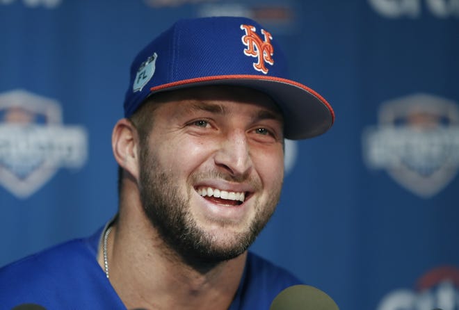 Outfielder and former NFL quarterback Tim Tebow laughs during a news conference at the New York Mets' spring training facility in Port St. Lucie. [John Bazemore/AP File]