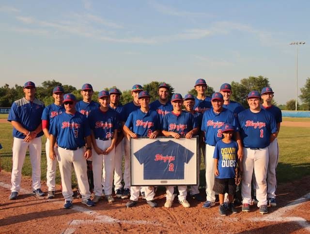 The 2018 Perry baseball team and head Coach Mike Long pose with his commemorative jersey. PHOTO BY LIBBIE RANDALL/THE PERRY CHIEF