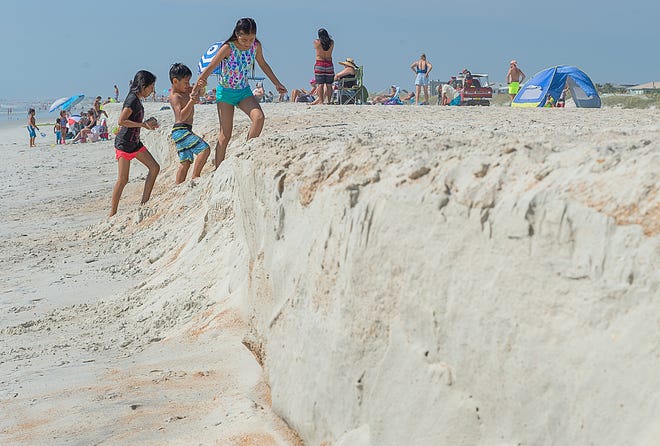 Children climb a ridge of sand on St. Augustine Beach, south of the St. Johns County Ocean and Fishing Pier, on Thursday. [PETER WILLOTT/THE RECORD]