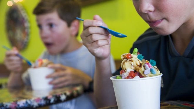 Reid Childers, 10, right, and his brother, Andrew Childers, 9, enjoy some frozen yogurt at Berry Austin on July 3. AMANDA VOISARD/AMERICAN-STATESMAN