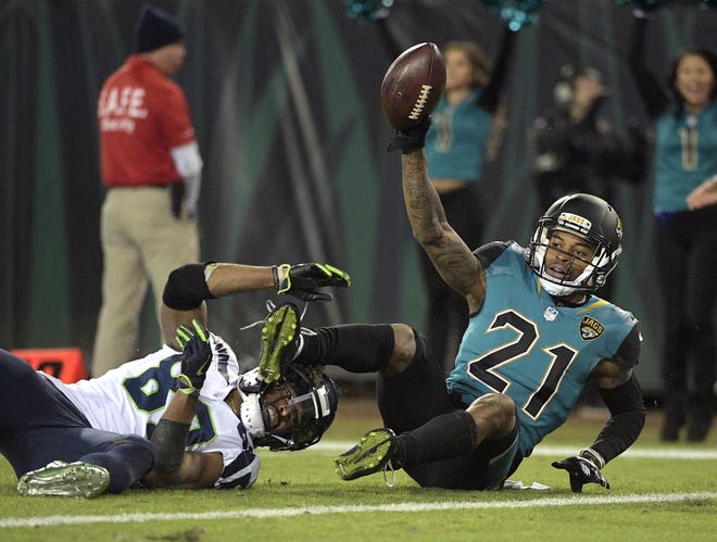 Jaguars cornerback A.J. Bouye (21) holds up the ball after he intercepted a pass in the end zone intended for Seattle Seahawks wide receiver Doug Baldwin during a 2017 game. [Phelan M. Ebenhack, The Associated Press]