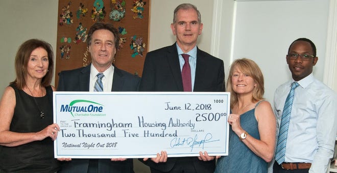 Celebrating MutualOne Charitable Foundation’s $2,500 grant to support National Night Out are, from left: Janice Rogers, commissioner of the Framingham Housing Authority; Mark Haranas, president and CEO of MutualOne Bank; Paul Landers, executive director; Janet Leombruno, commissioner of the Framingham Housing Authority; and Yves Munyankindi, retail support and charitable foundation administrator at MutualOne Bank. [Courtesy Photo]