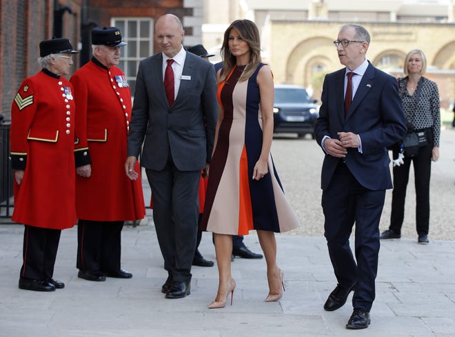 U.S. First Lady Melania Trump, is accompanied by Philip May, the husband of British Prime Minister Theresa May as she meets British military veterans known as "Chelsea Pensioners" at The Royal Hospital Chelsea in central London Friday, July 13, 2018. The pensioners, known for their scarlet coats and tricorne hats are a cherished British institution and are often seen parades, state events and other grand occasions.(AP Photo/Luca Bruno, Pool)
