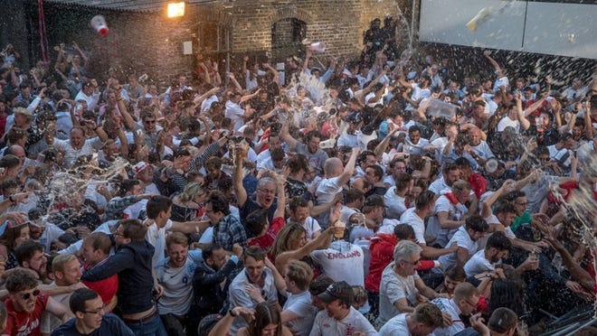 Fans at the historic George Inn on the Borough High Street in London celebrate as England scored in their World Cup semifinal with Croatia, July 11, 2018. For countries reaching the latter stages, the World Cup becomes something of a national fixation, sweeping along even those who have little or no interest in sports, and people come together to watch as one. (Andrew Testa/The New York Times)