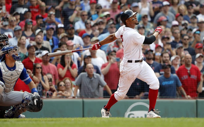 Red Sox shortstop Xander Bogaerts watches his grand slam in the 10th inning of a 6-2 walk-off win over the Toronto Blue Jays at Fenway Park on Saturday. [WINSLOW TOWNSON/THE ASSOCIATED PRESS]