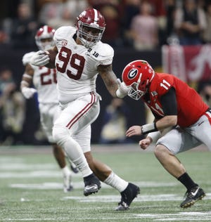 Alabama defensive lineman Raekwon Davis returns a pass he intercepted from Georgia quarterback Jake Fromm (11) during the College Football Playoff Championship Game at the Mercedes-Benz Stadium in Atlanta on Jan. 8. Alabama defeated Georgie 26-23 in overtime to claim the championship. [Gary Cosby Jr./GateHouse Media Services/File]