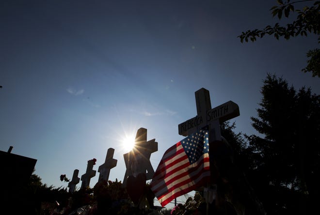 An American flag is placed next to four crosses and a Star of David representing the journalists killed, at a makeshift memorial outside the office building housing The Capital Gazette newspaper in Annapolis, Md., Sunday, July 1, 2018. Jarrod Ramos is charged with murder after police say he opened fire Thursday at the Gazette offices in Annapolis. (AP Photo/Jose Luis Magana)