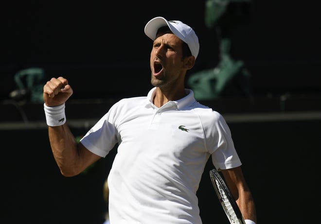 Novak Djokovic celebrates winning a point from Kevin Anderson during the men's singles finals at the Wimbledon Tennis Championships in London on Sunday. [NEIL HALL/POOL VIA AP]