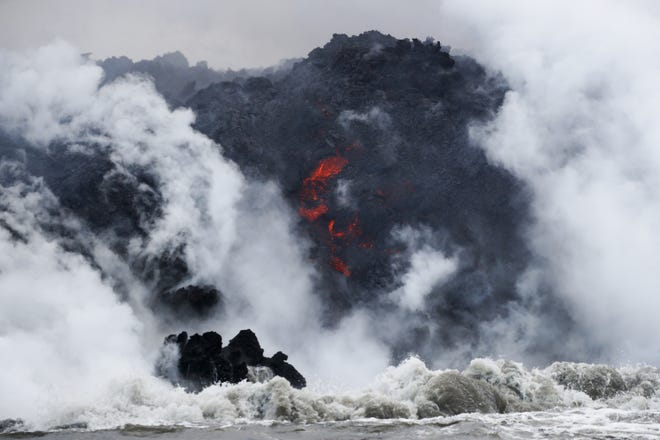 FILE - In this May 20, 2018 file photo, lava flows into the ocean near Pahoa, Hawaii. Officials say an explosion sent lava flying through the roof of a tour boat off the Big Island, Monday, July 16, 2018, injuring at least 13 people. The people were aboard a tour boat that takes visitors to see lava from an erupting volcano plunge into the ocean. (AP Photo/Jae C. Hong, File)