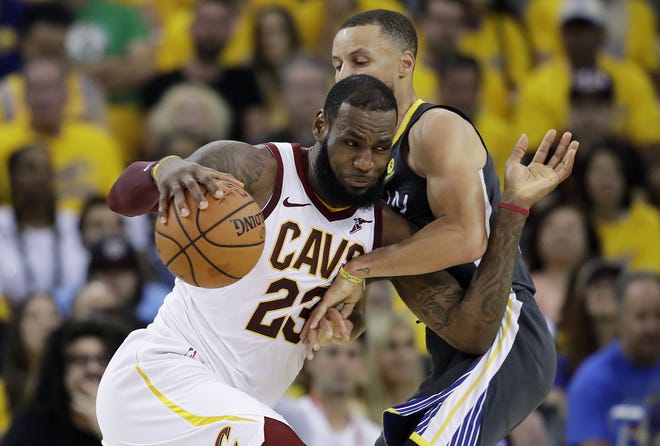 LeBron James, left, drives against Golden State Warriors guard Stephen Curry during the NBA finals in Oakland, Calif. James is signed as a free agent with the Los Angeles Lakers this offseason. [AP PHOTO/MARCIO JOSE SANCHEZ]