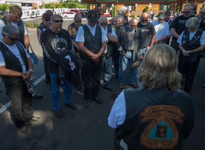 A prayer is offered among riders during the opening ceremony of the Tribute to Fallen Soldiers NW Memorial Torch Motorcycle Ride at Valley River Center in Eugene on Tuesday. [Brian Davies/The Register-Guard] - registerguard.com