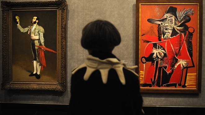 FILE PHOTO: A member of the press looks at Picasso's painting "Mousquetaire a l'epee assis" (R) which is displayed next to Edouard Manet's "Matador saluant" on October 6, 2008 in Paris, France. The exhibition of "Picasso et les Maitres" will open to the public on October 8, 2008 until February 2, 2009 at the Grand Palais, simultaneously the Musee d'Orsay and the Musee du Louvre are also coinciding with exhibitions on Picasso. (Photo by Pascal Le Segretain/Getty Images)