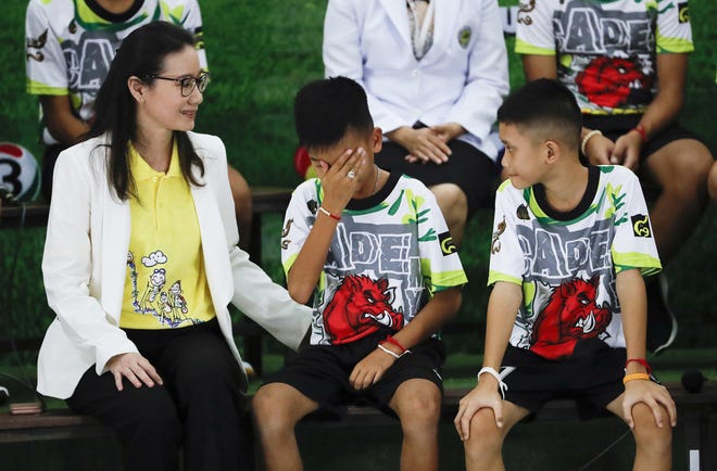 Rescued soccer player "Titan" Chanin Vibulrungruang reacts after paying respect to a portrait of Saman Gunan, the Thai Navy SEAL diver who died in the rescue attempt, during a press conference discussing their ordeal in Chiang Rai, northern Thailand, Wednesday, July 18, 2018. The 12 boys and their soccer coach rescued after being trapped in a flooded cave in northern Thailand are recovering well and are eager to eat their favorite comfort foods after their expected discharge from a hospital soon. (AP Photo/Vincent Thian)