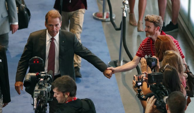 Alabama coach Nick Saban is greeted by a fan as he arrives at the SEC Media Days on Wednesday at the College Football Hall of Fame in Atlanta. [AP Photo/John Bazemore]