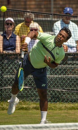 Leander Paes follows through on a serve Wednesday during a doubles match with partner Jamie Cerretani at the Dell Technologies Hall of Fame Open. Paes, 45, turned pro in 1991 and has won 54 career doubles titles, including 18 Grand Slams between men's and mixed doubles. [DAVE HANSEN/STAFF PHOTOGRAPHER]