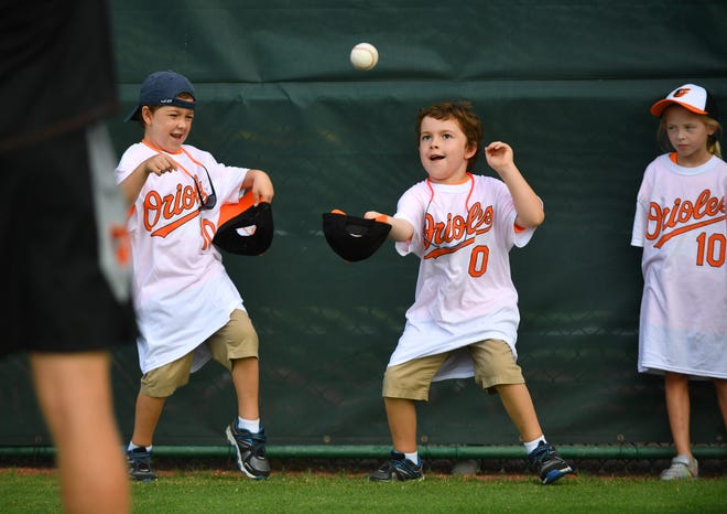 Caden Vickers, left, and his twin brother Holden Vickers, both 6, take turns catching a ball in their hat as Molly Gillespie, 6, right, waits her turn. [Herald-Tribune staff photo / Mike Lang]